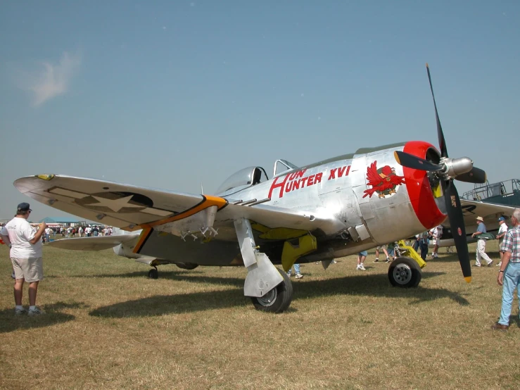 a small silver airplane with a red and black nose