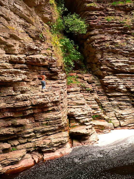 the man is standing at the end of the cliff