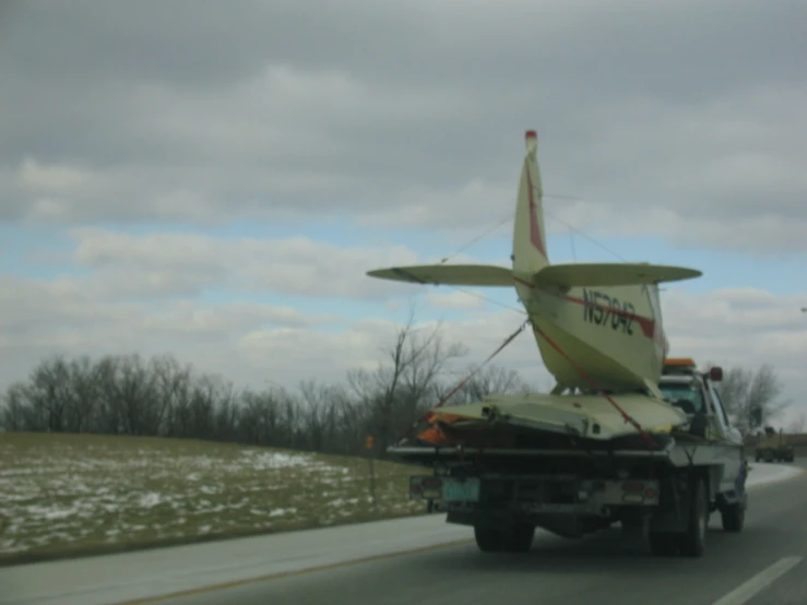 a truck carries a plane on the back of it