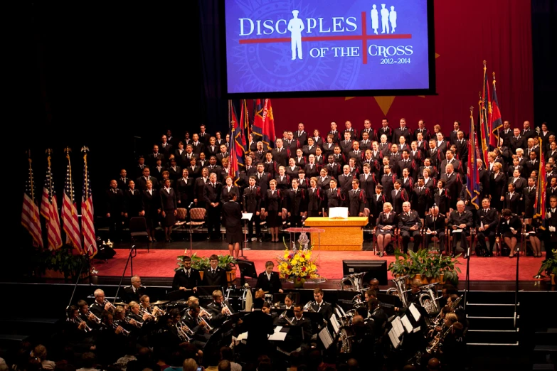 a very large choir on a stage with a big screen