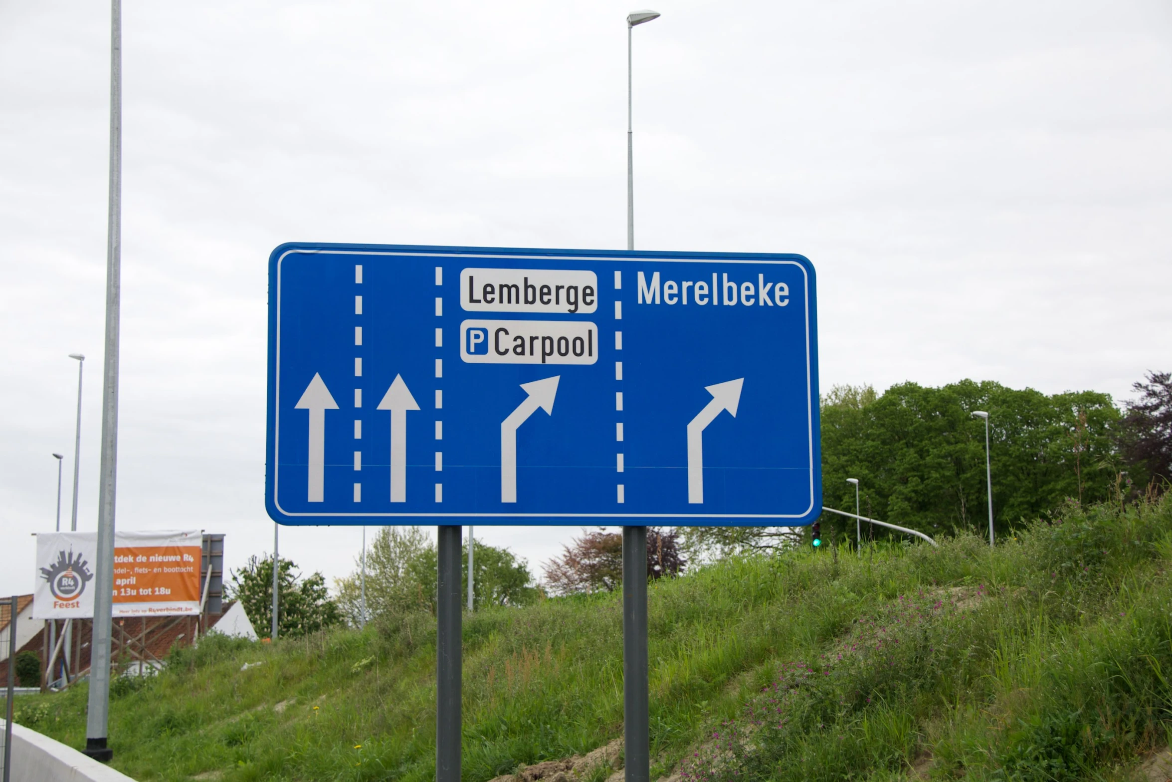 blue highway sign on side of highway near city