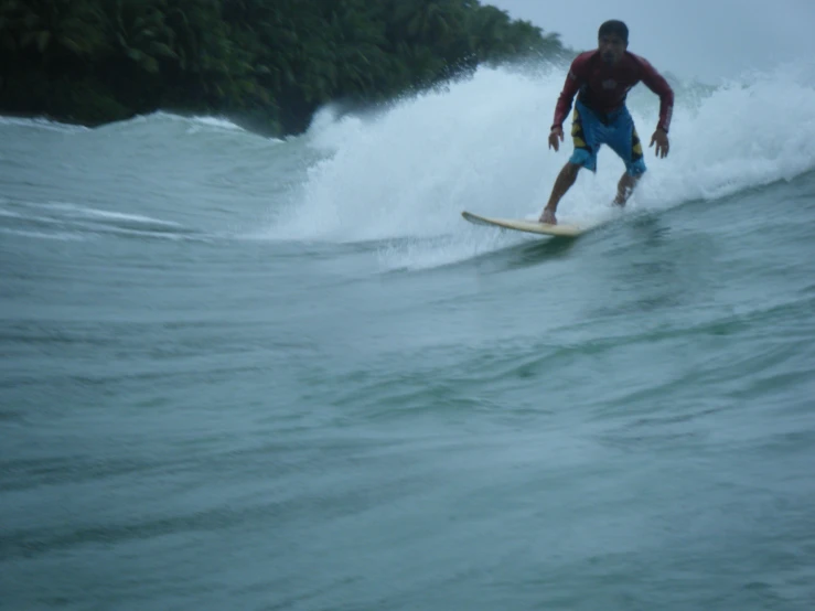 a man riding a wave on top of a surfboard