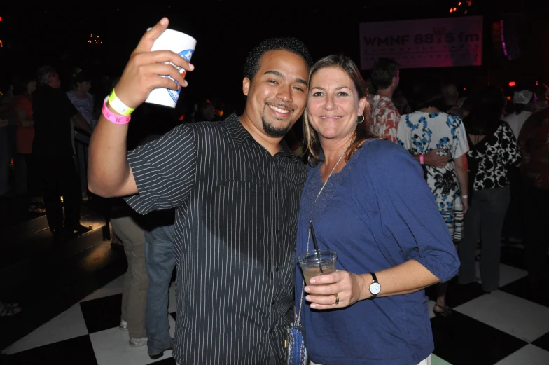 a man and a woman take pictures with their cell phones