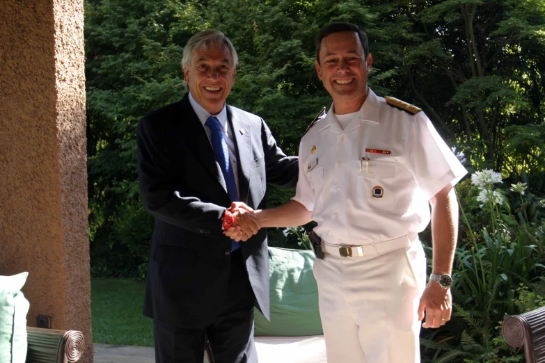 two men in military uniforms, one shaking the other hand