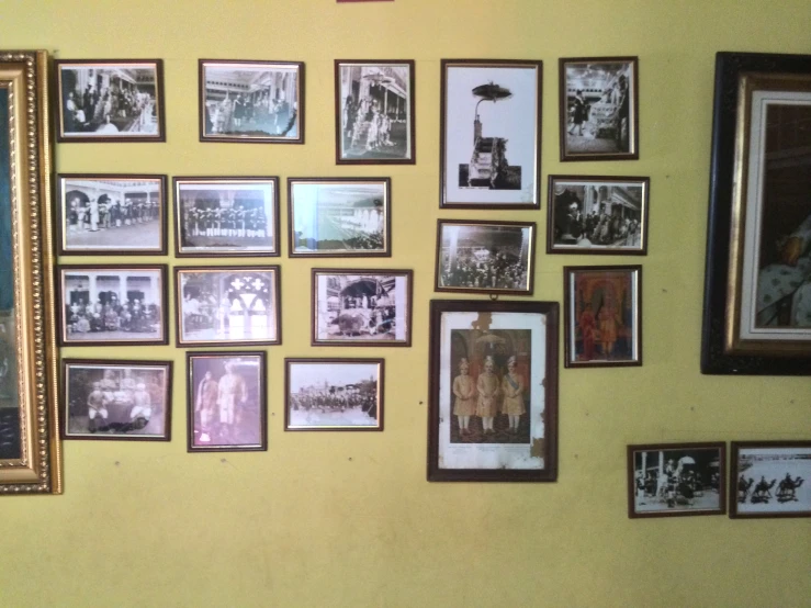 a collection of pictures hung on the wall with many frames