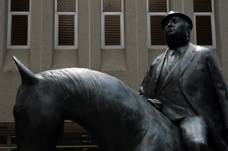 a man on a horse statue in front of a building