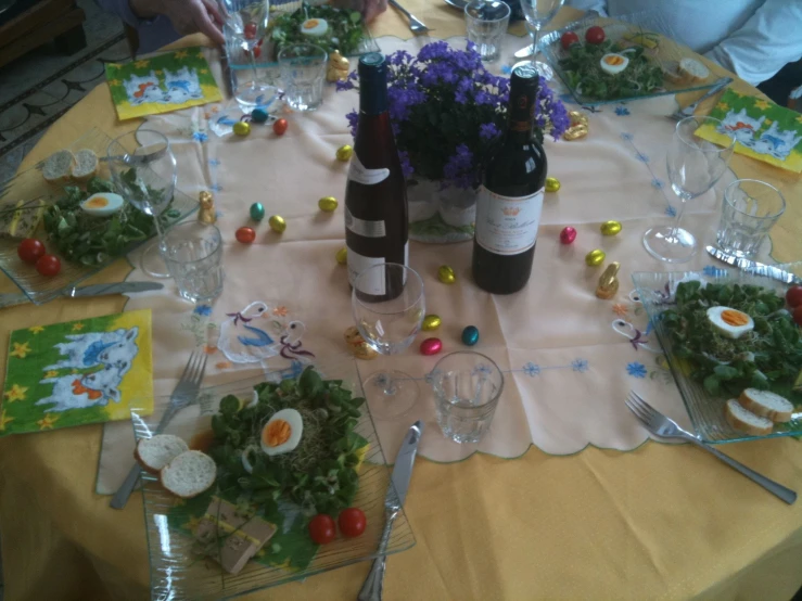 bottles of wine, food and salad sitting on a table