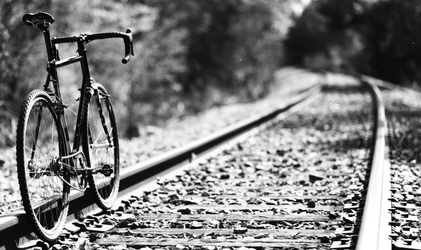 the bicycle is sitting on the railroad track