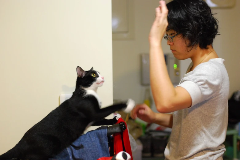 a woman petting her cat next to a wall