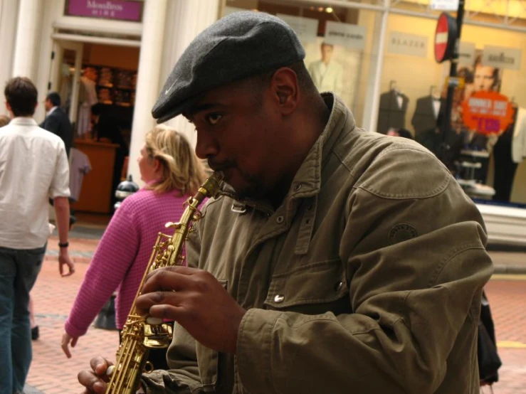 there is a man that is playing the saxophone on a street