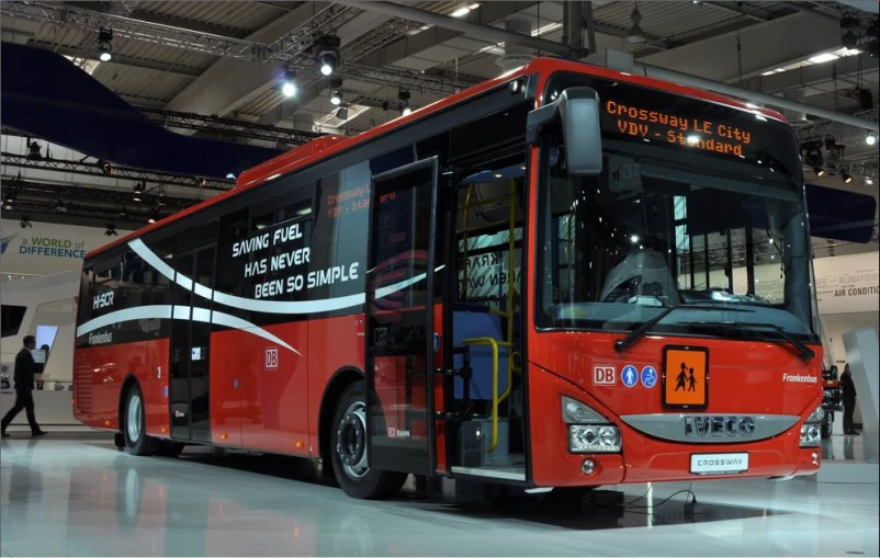 a large red bus is on display at a car show