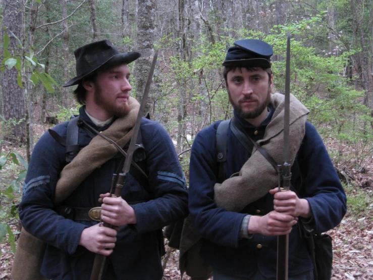 two men in uniforms with guns and hats