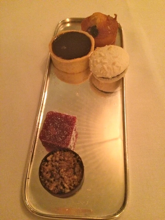 there are desserts arranged in individual sections on a metal tray