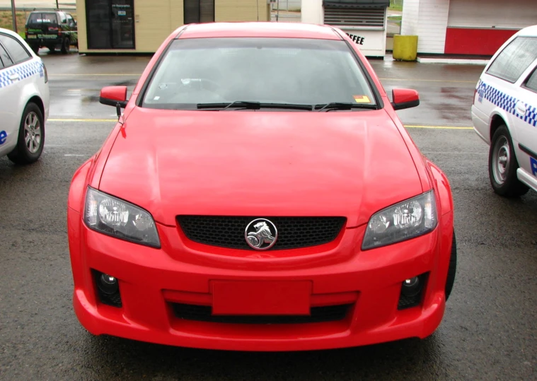 a red car parked next to a white police car