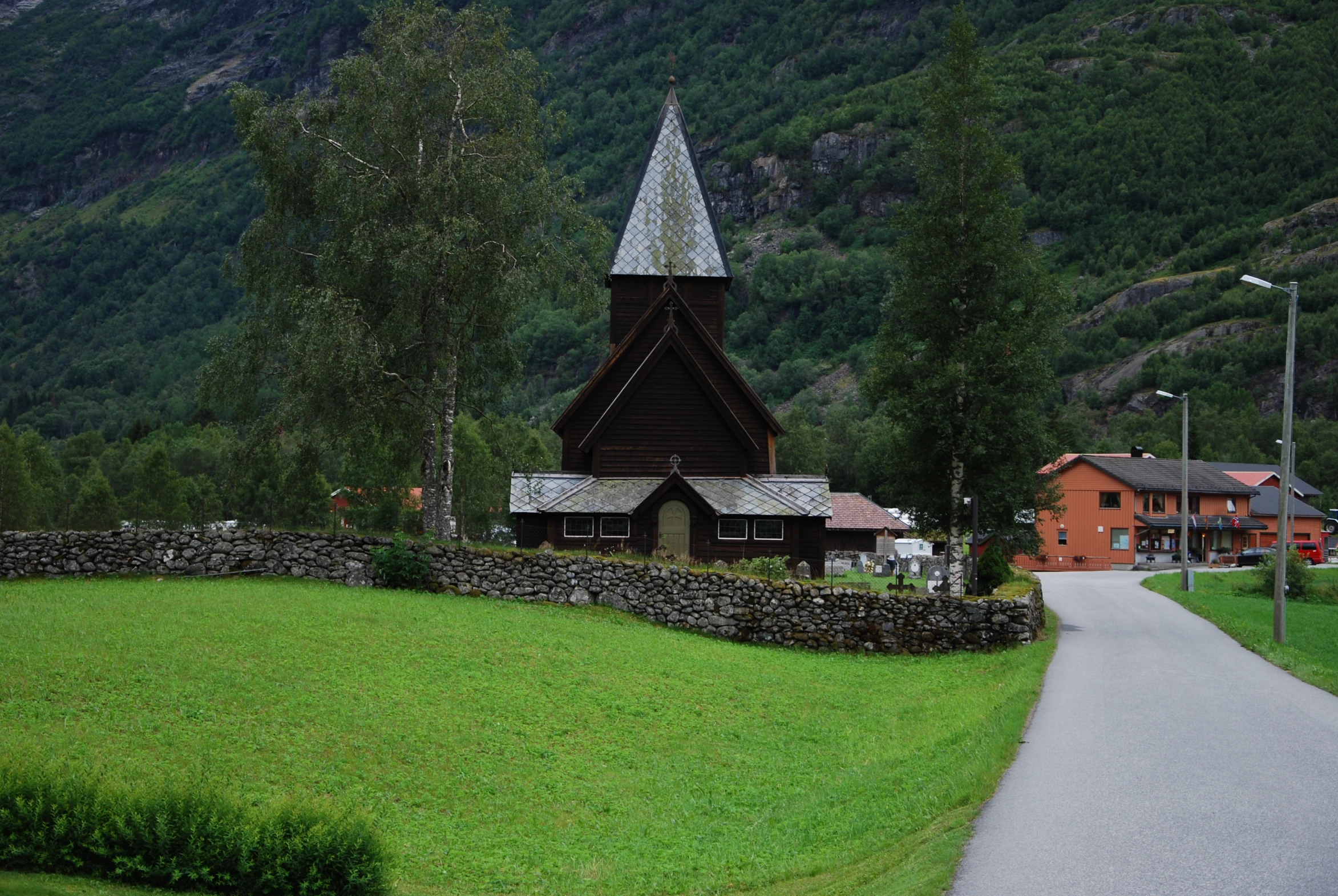 a small church and some houses on a hill side