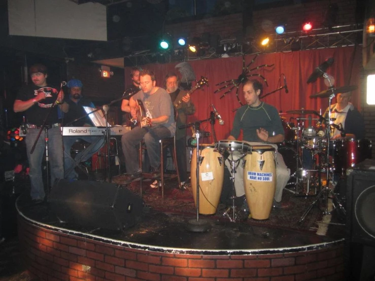 people sitting around playing music on stage