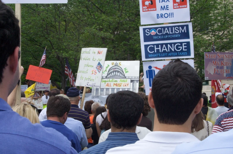 a crowd of people holding up signs and holding out their hands