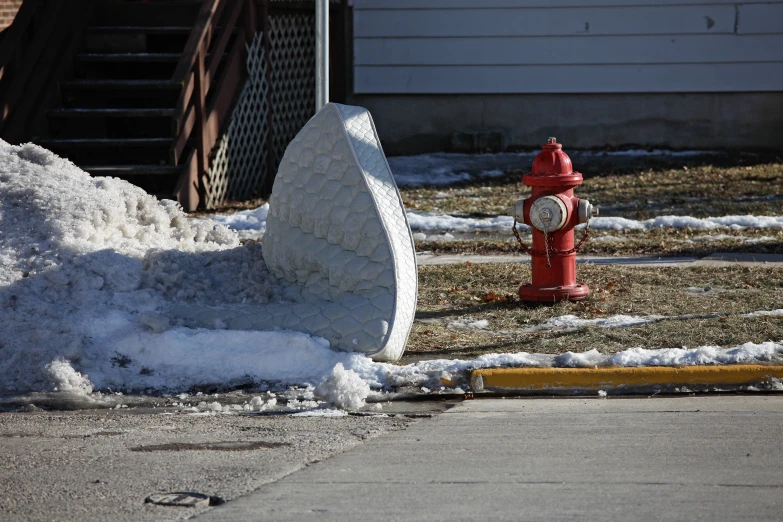 a red fire hydrant sitting next to a pile of snow