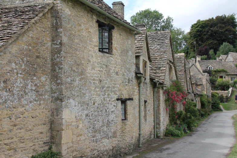 a sidewalk lined with stone cottages in a village