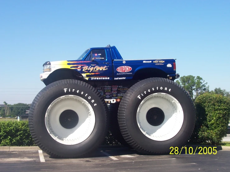 a truck tire with large tires that are parked in a parking lot