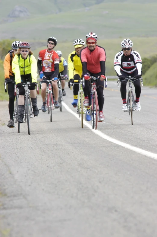 a group of cyclists that are going up a road