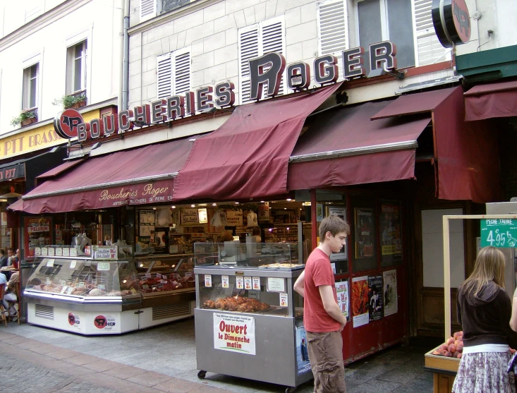 a man standing in front of a store called a burger bar