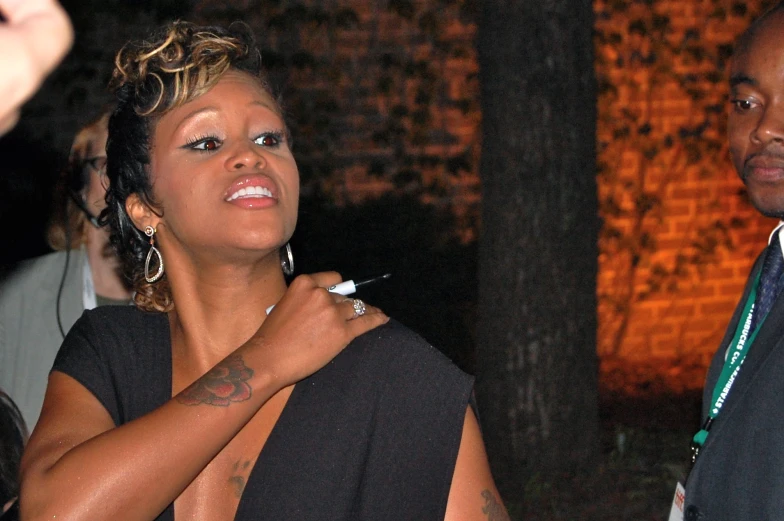 a woman is lighting lipstick for an award ceremony