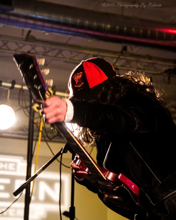 a masked musician performing with an electric guitar