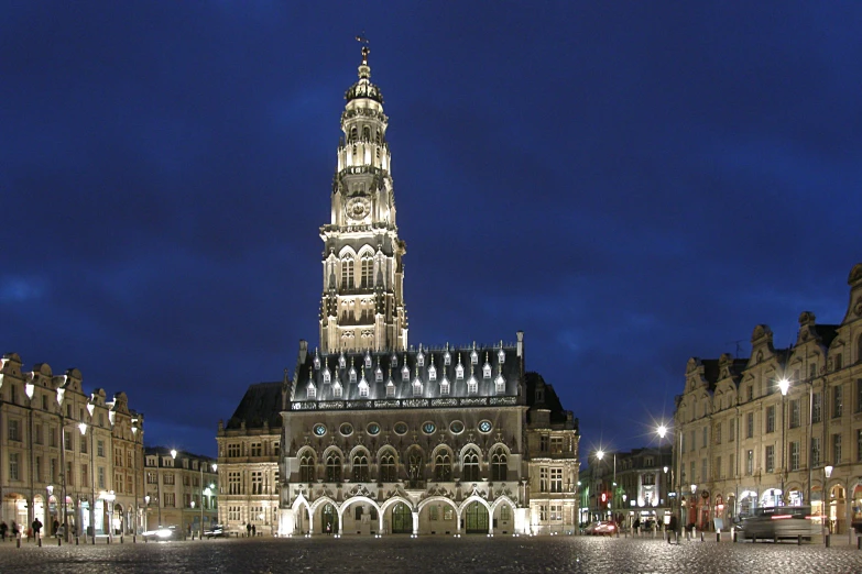 an illuminated clock tower towering over some buildings