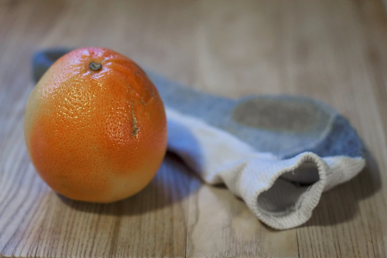 an orange and sock on a wooden table