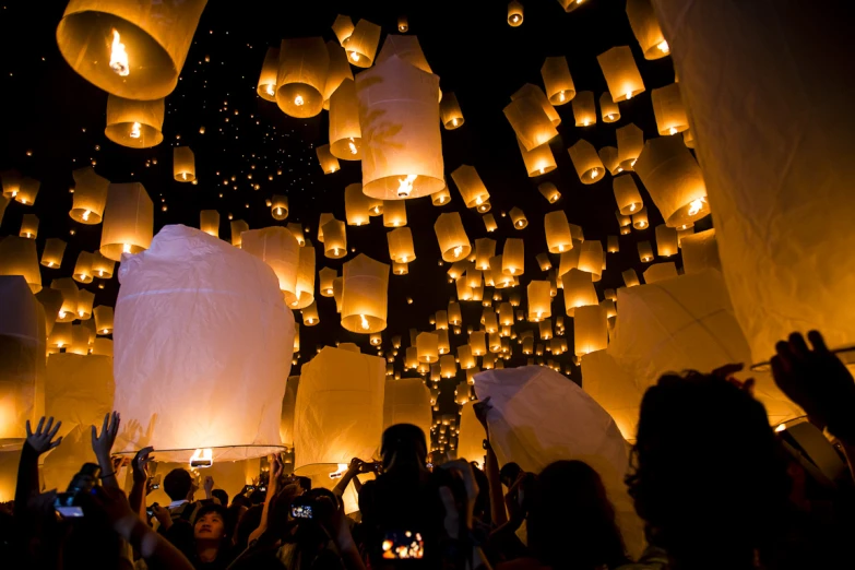 people are flying lanterns in the air