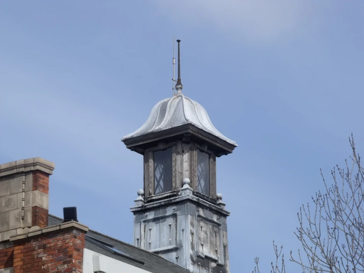 a tall building with a clock tower and a weather vane