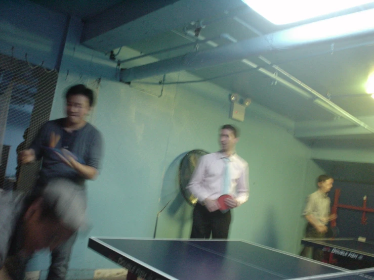 two men are standing next to a ping pong table