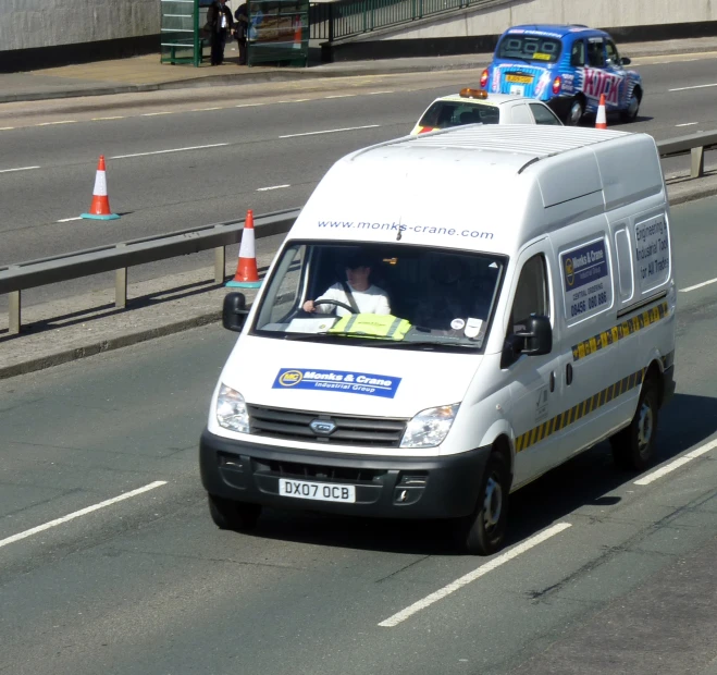 a white van is driving on a city street