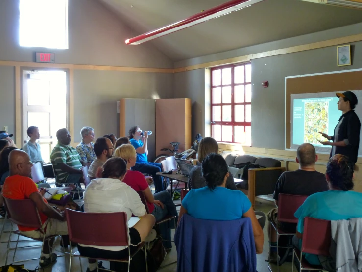 group of people sitting in chairs in front of a classroom