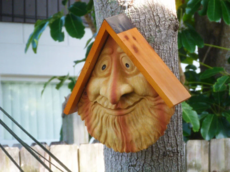 a wooden face on a tree is peeking out of the corner