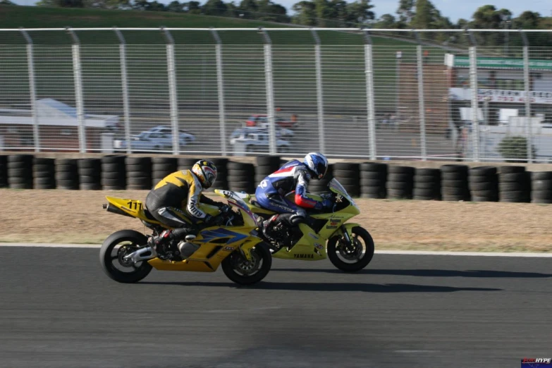 two motorcycle racers race down the track on their respective bikes