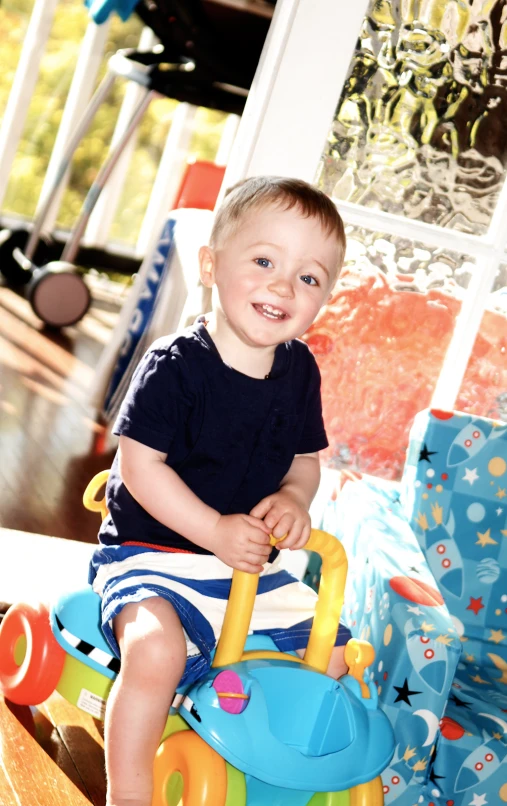 a little boy sitting on a toy bike