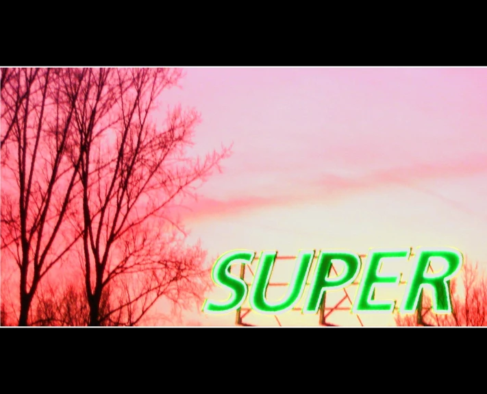 the word super is projected on a building with bare trees