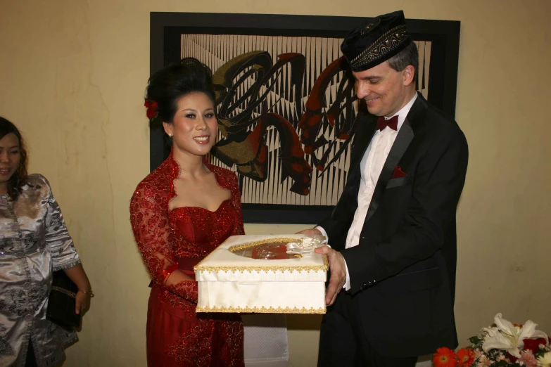 a couple is presented a cake as a wedding reception