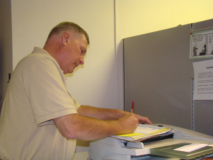 a man is at a work desk using a printer