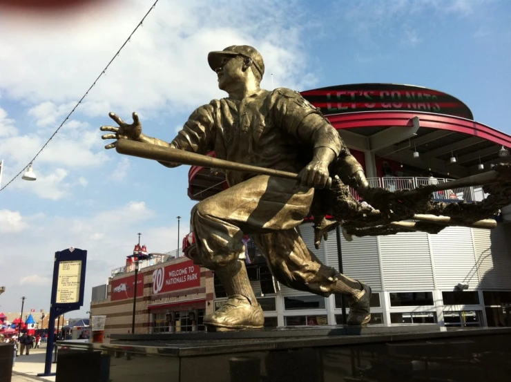 a statue is posed in front of a stadium