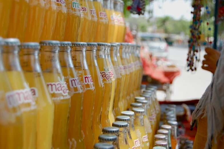 a large rack filled with orange sodas for sale