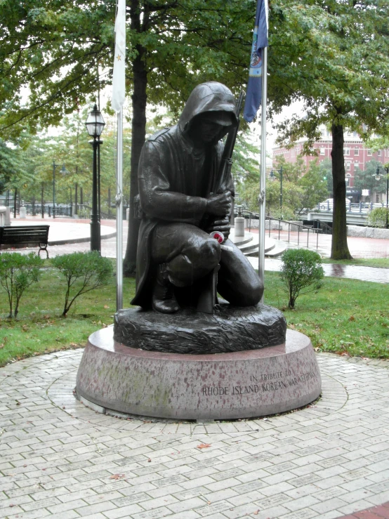 a monument with a woman and child near some trees