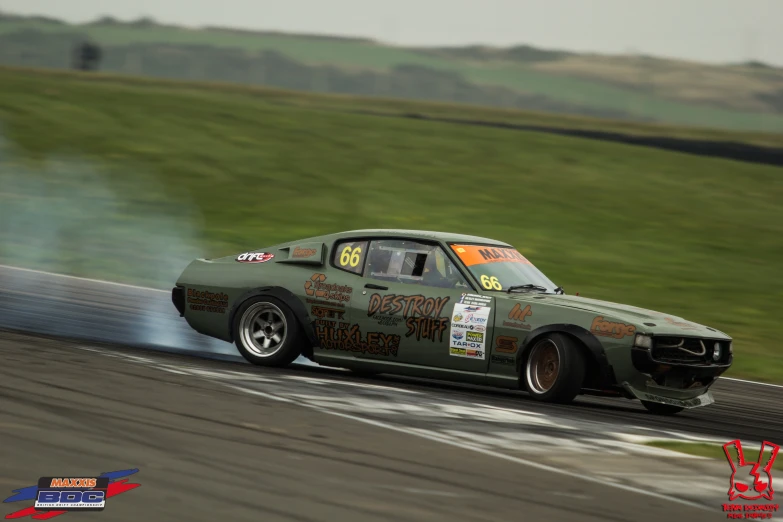 the green mustang that is blowing smoke while driving