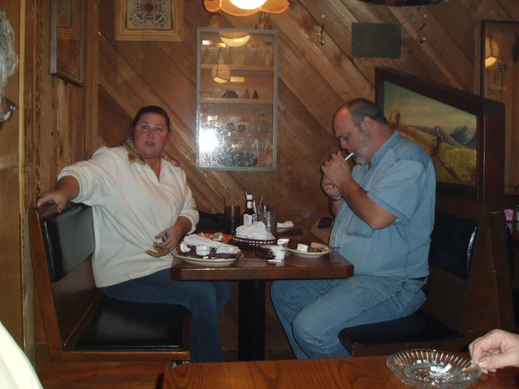 two women and one man sitting at tables in a restaurant