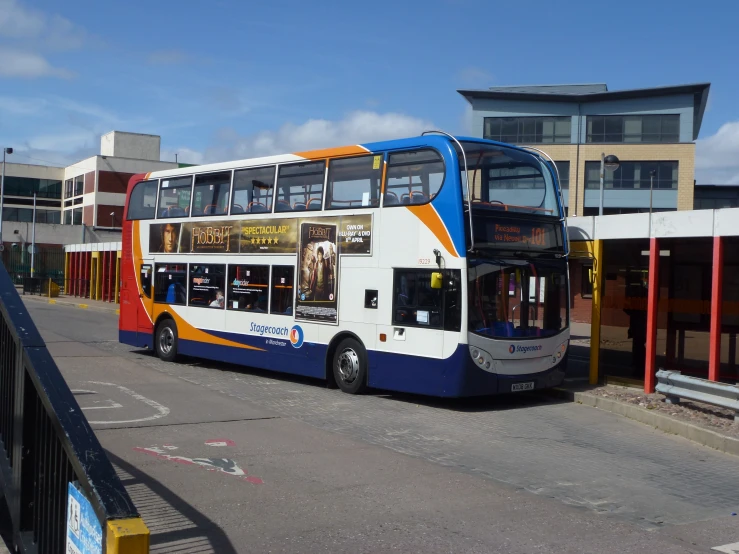 a two story bus parked near some building