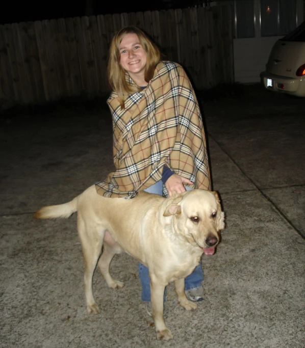 a woman sits on a man's knee with a dog