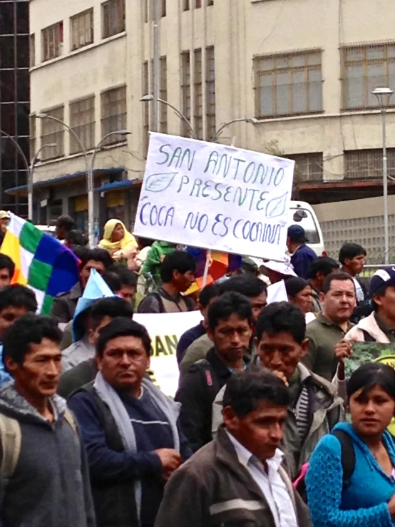 a bunch of people holding signs and standing on the street