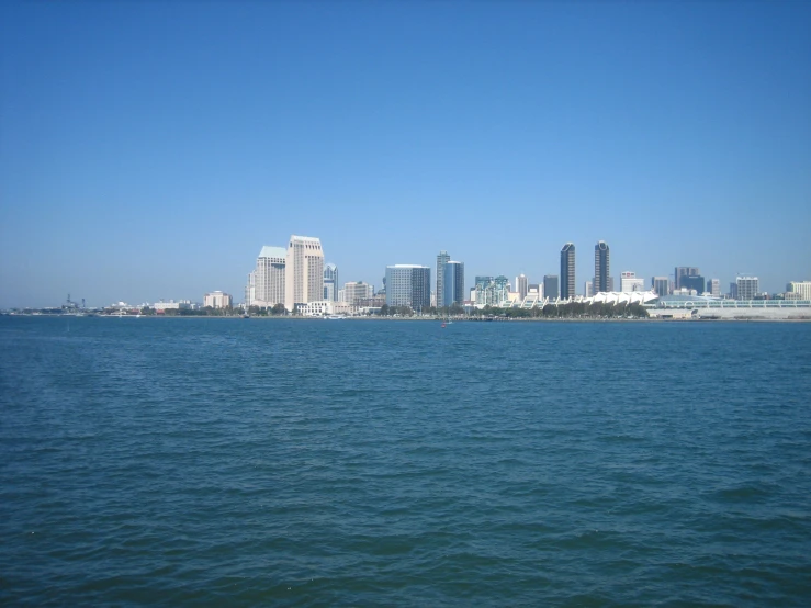 an ocean with tall buildings in the distance